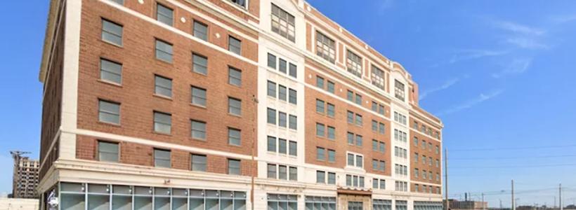 A seven story apartment building with red and white brick exterior.